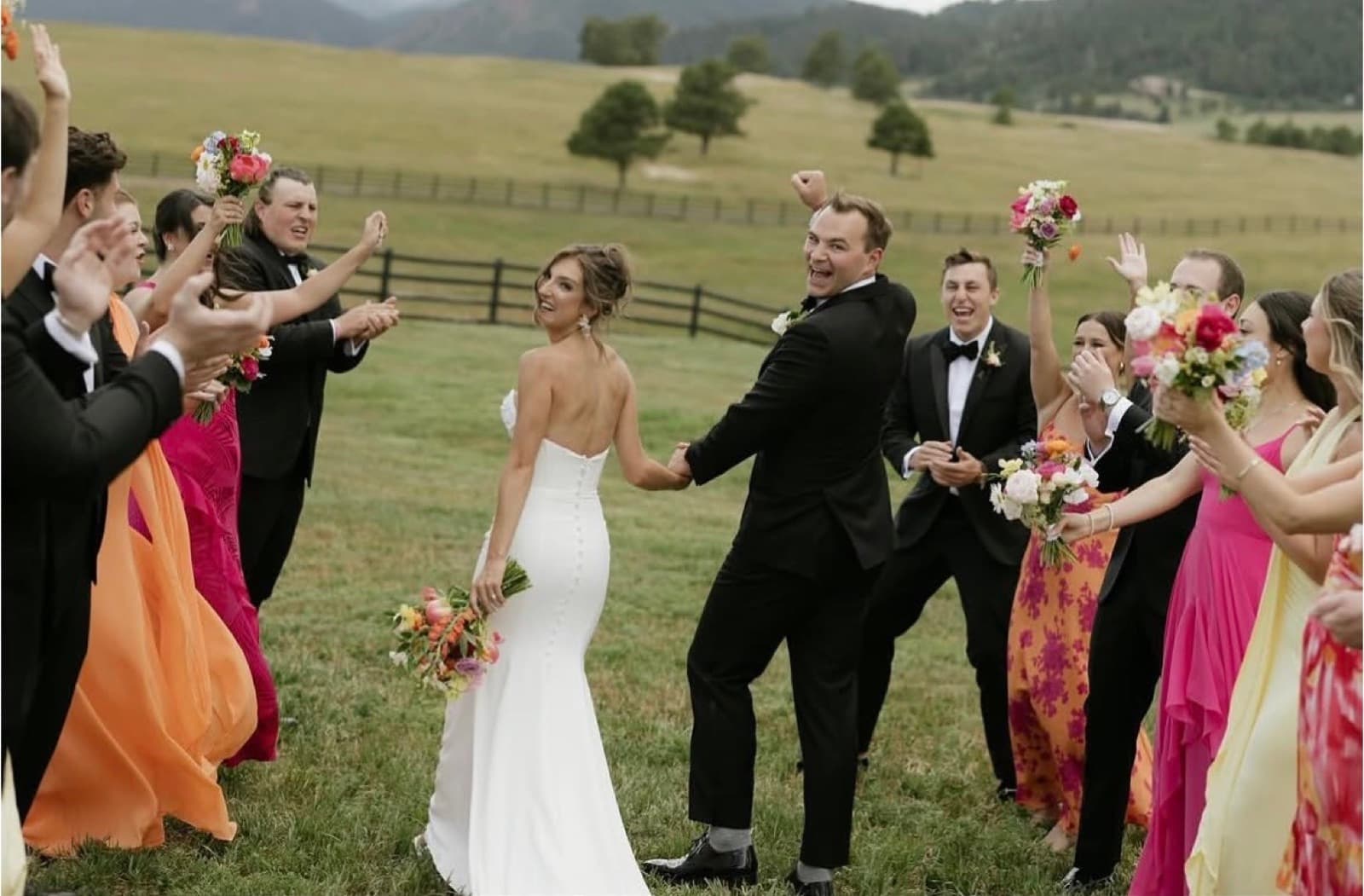 Wedding couple celebrating with their bridal party on a mountain meadow ranch